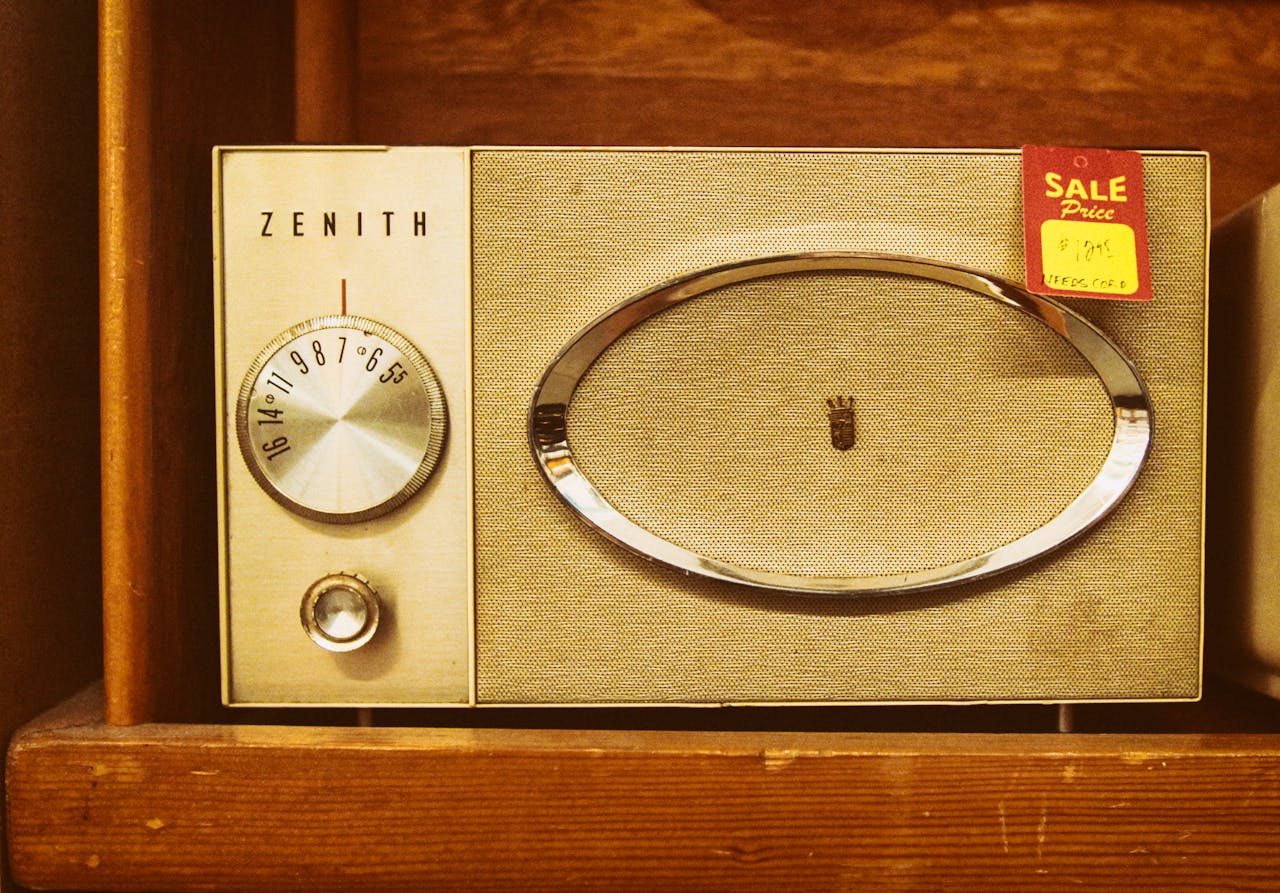about-01 Close-up of a vintage Zenith radio with a sale tag on a wooden shelf, showing dials and speaker design.
