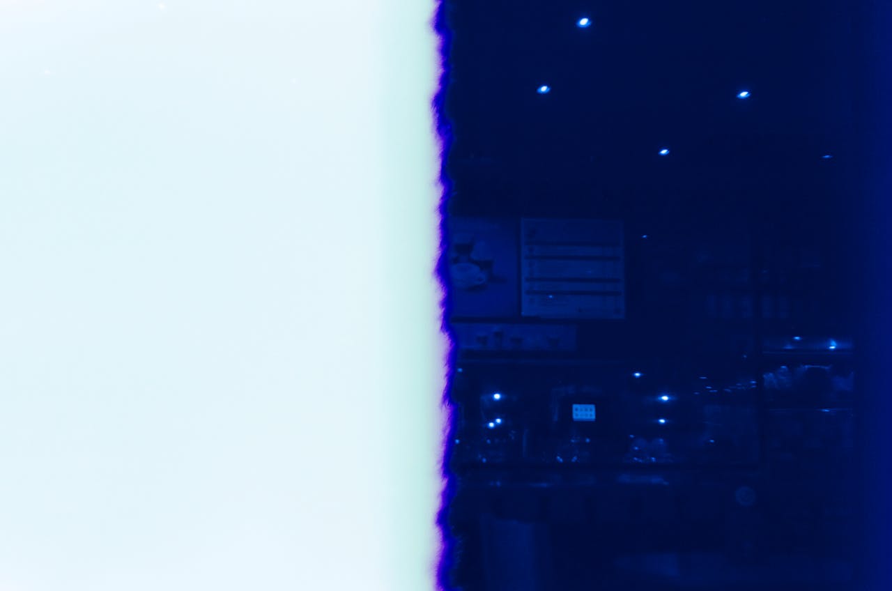 hero-img-02 Artistic film photo displaying a dramatic light leak on a dark blue background.